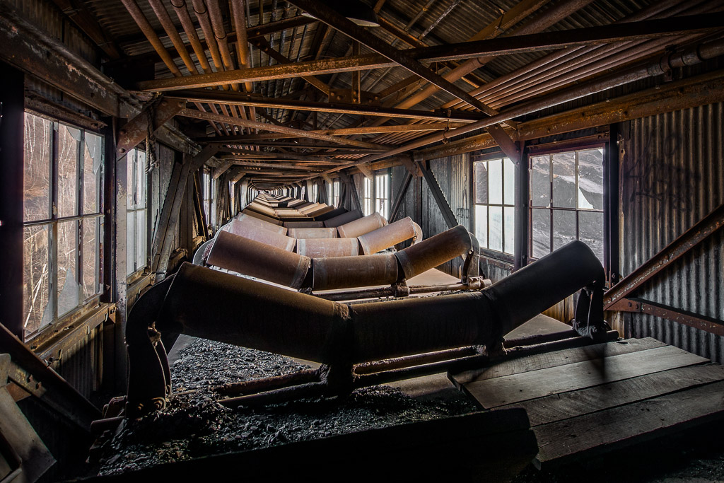 I was not at all sure how sound the top of this thing was, but it was good enough for me to climb out and get a shot looking down the long chute that brought the coal up -- minus the very long belt.

These are just a teaser from my first visit to an abandoned coal breaker in the western middle fields of central Pennsylvania's anthracite coal country.  I arrived there just before sun up and shot throught the early morning.

Taken with a Panasonic G5 (DMC-G5) and Olympus 9-18mm lens.

Please visit the <a href=