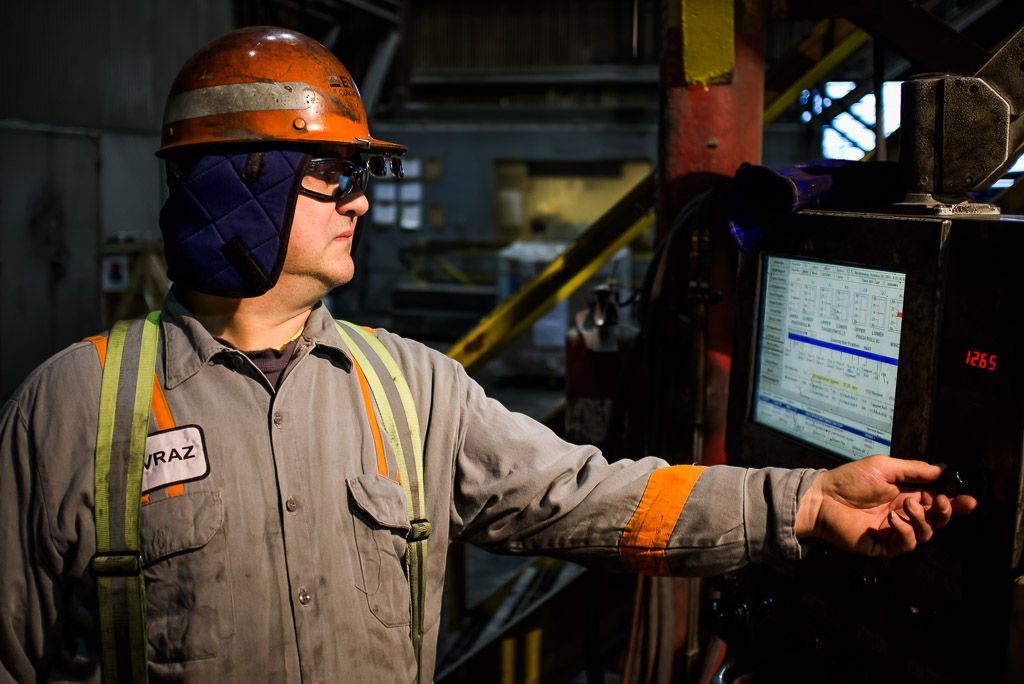 A caster technician keeps an eye on the drive section and adjusts the speed.  Later he will descend several stories down to the exit of the machine to supervise the disconnection of the 