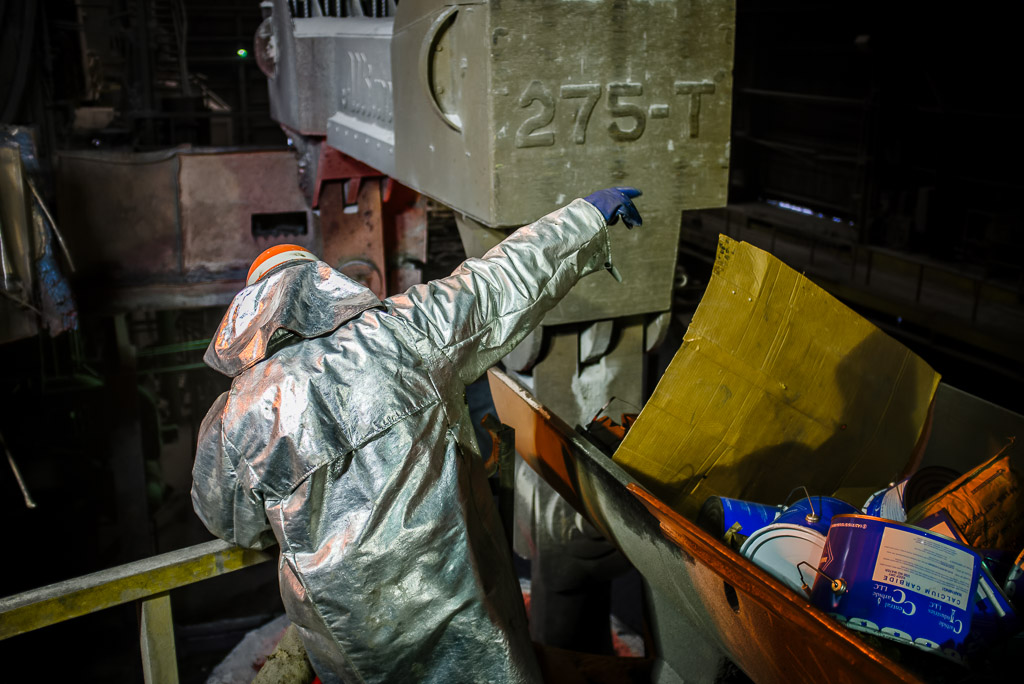 Sometimes the Melter really is like a conductor directing an orchestra of men that have to work together to safely and successfully make a heat.  Here the melter directs the ladle cran as to exactly where to place the ladle.  Next to him is the hopper with fluxing, 